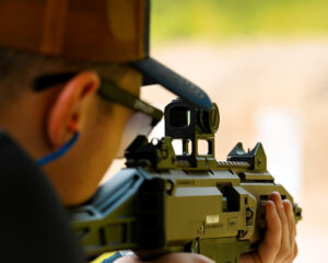 Man at the shooting range using a firearm with an optic attached