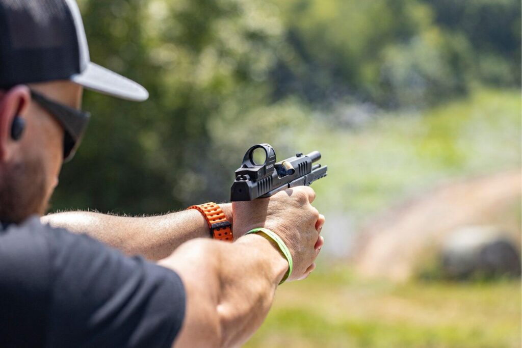 man practicing shooting drills at an outdoor gun range