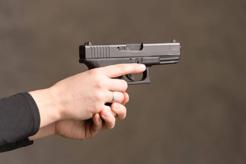 hands holding and aiming a compact pistol
