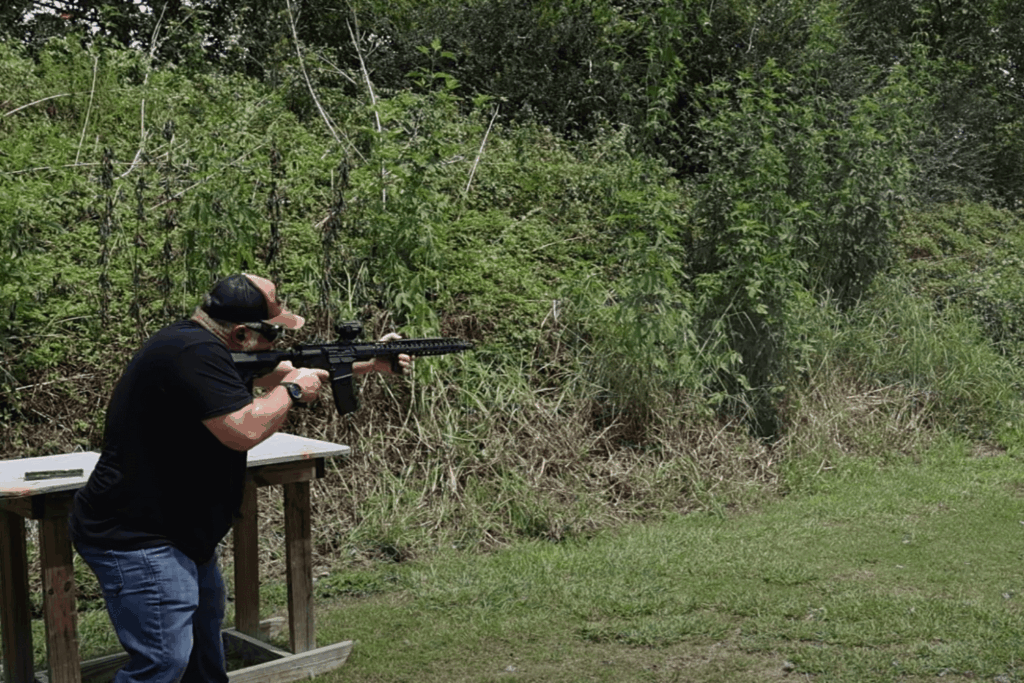 A man firing an AR-15 at a target at an outdoor shooting range - Gideon Optics A man firing an AR-15 at a target at an outdoor shooting range