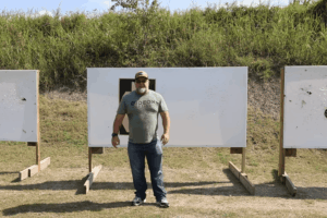 Mike from Gideon Optics standing at an outdoor shooting range as he films a video on concealed carry tips