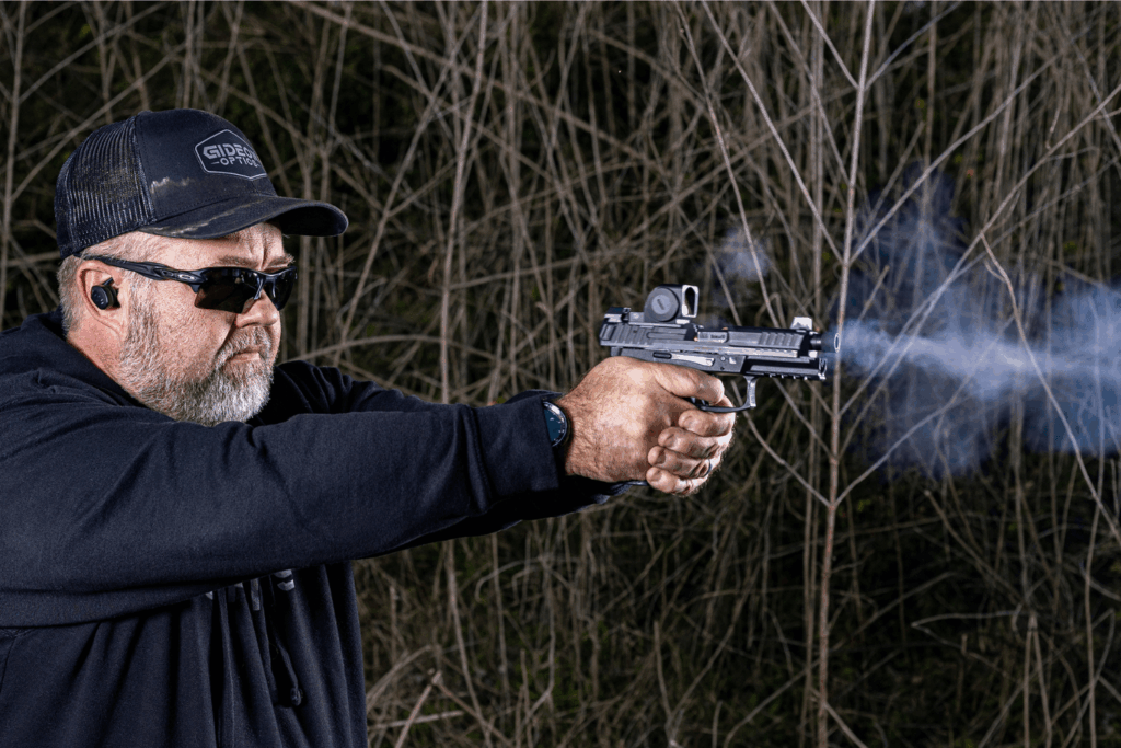 red dot unlimited eye relief - Gideon Optics Man in all black wearing sunglasses and ear protection firing a pistol with a Gideon Optics red dot mounted
