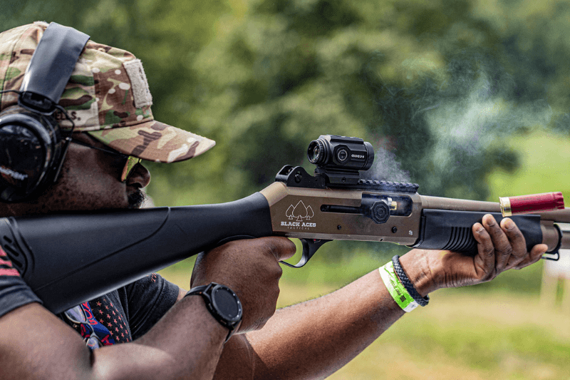 Man shooting a shotgun with a Gideon Optics Advocate prism sight mounted