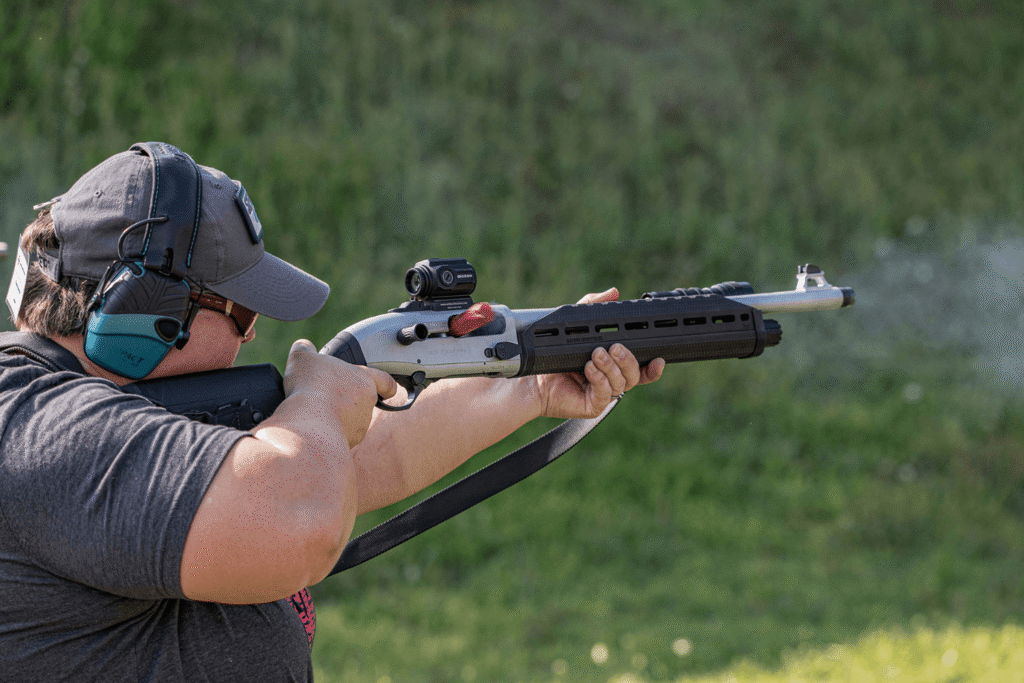 man firing a shotgun with a Gideon Optics Advocate mounted at an outdoor shooting range
