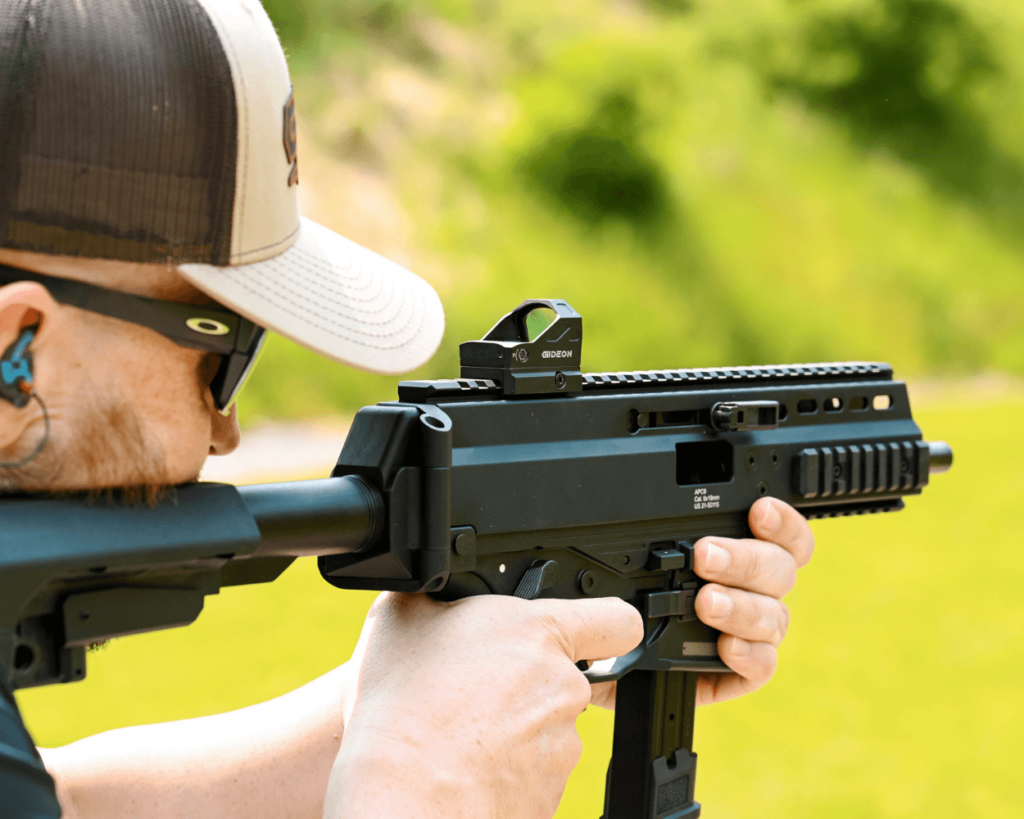 Man aiming an APC9 that has a Gideon Optics red dot mounted