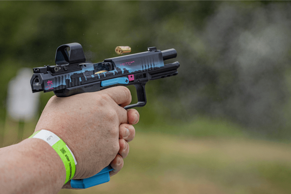 Hands aiming a pistol with a Gideon Optics red dot mounted