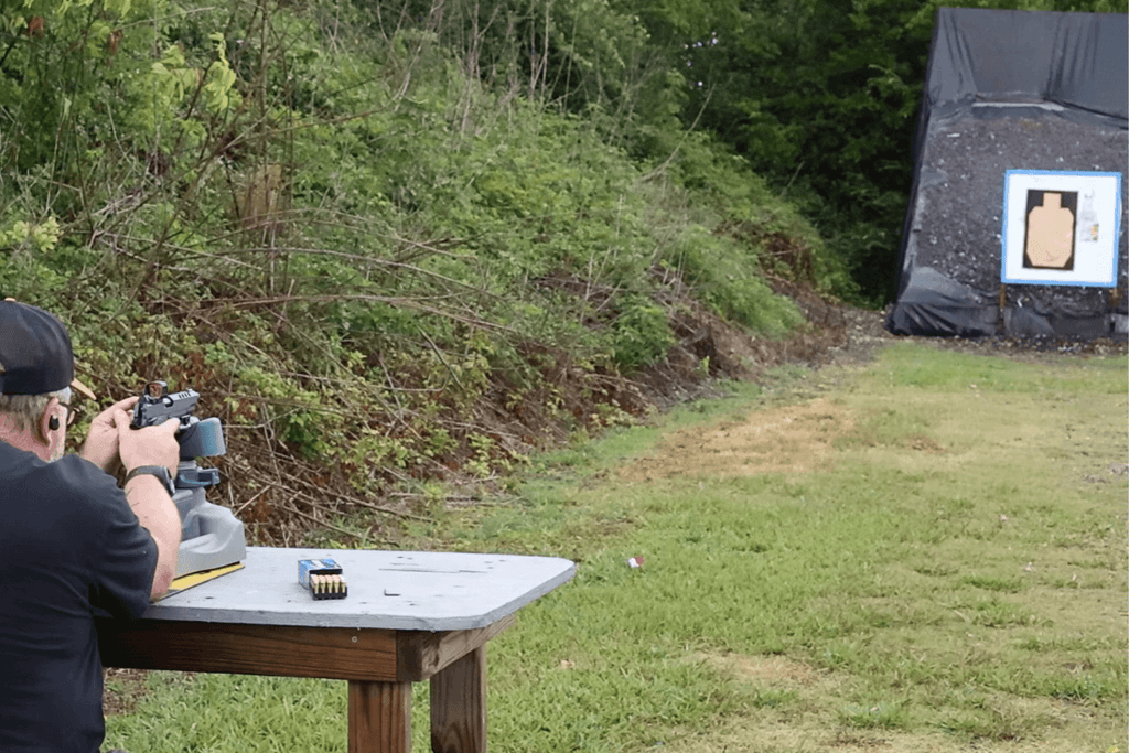 reconfirming zero - Gideon Optics Mike from Gideon Optics aiming his pistol at a target while zeroing his optic at an outdoor range